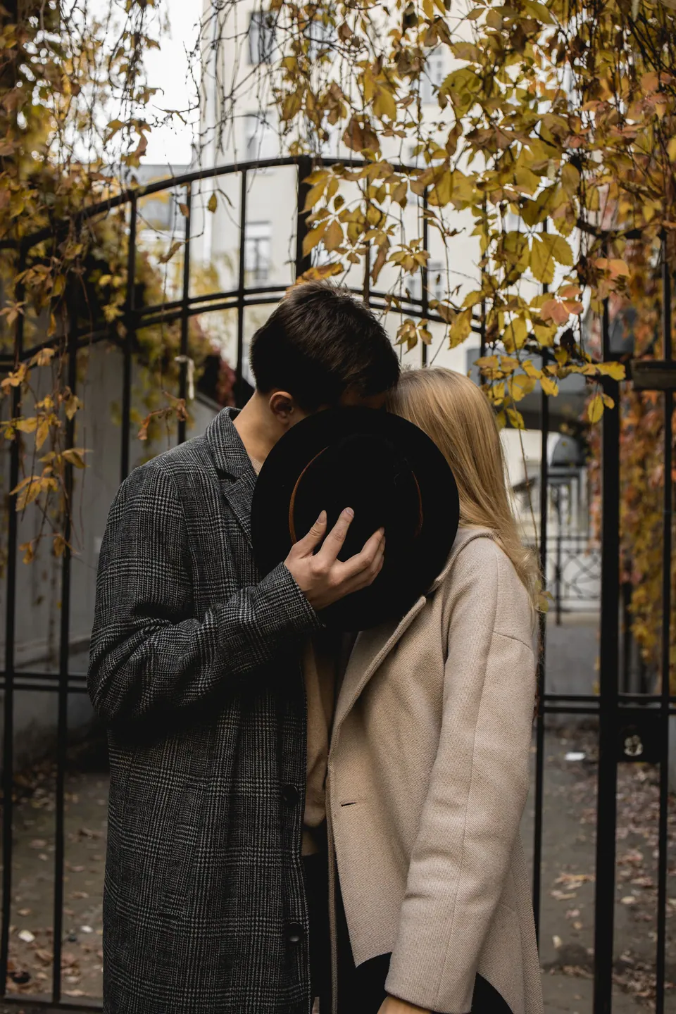 A couple sharing a private moment behind a hat